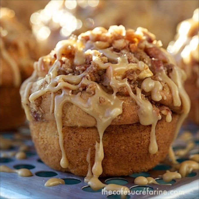 Vertical closeup photo of Caramel Apple Buttermilk Muffins with caramel icing on a metal cooling rack.