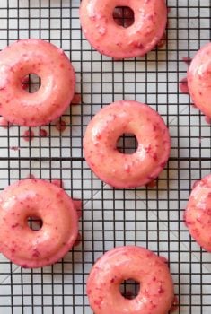 Overhead picture of Baked Buttermilk Donuts with Fresh Starwvberry Glaze on a cooling rack