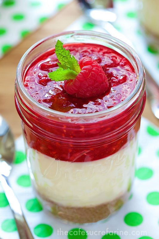 Layered Cheesecake Jars. Golden, buttery graham cracker crust covered with light creamy cheesecake and topped with fresh raspberry sauce. A heavenly combination!!