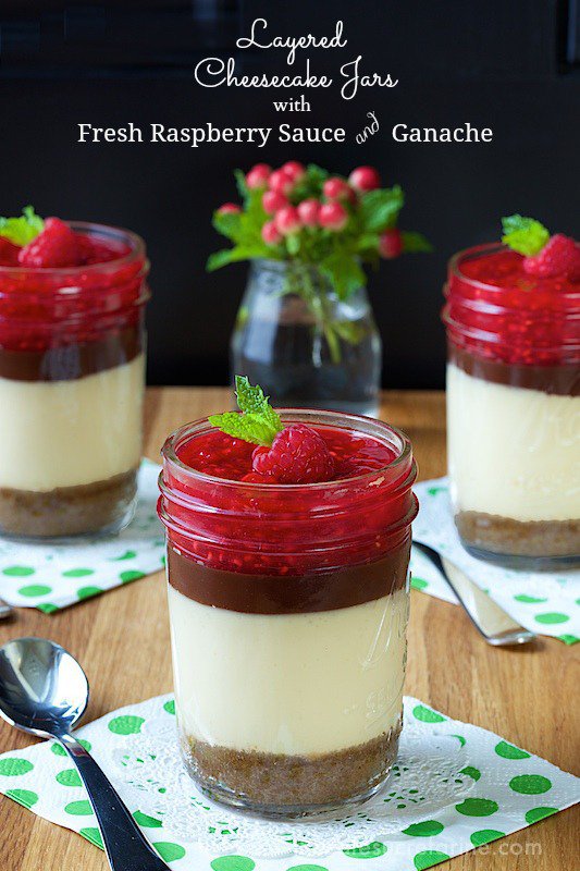 Layered Cheesecake Jars. Golden, buttery graham cracker crust covered with light creamy cheesecake, a layer of silky smooth ganache and fresh raspberry sauce. A heavenly combination!!