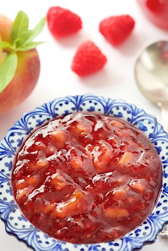 It takes just thirty minutes to throw together a batch of this yummy Peach Raspberry Freezer Jam! It's really easy and you'll be thanking yourself over and over, when the cold winds blow! www.thecafesucrefarine.com