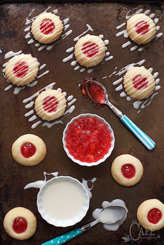 Overhead picture of Peach Raspberry Thumbprint Cookies on a sheet pan drizzled with glaze
