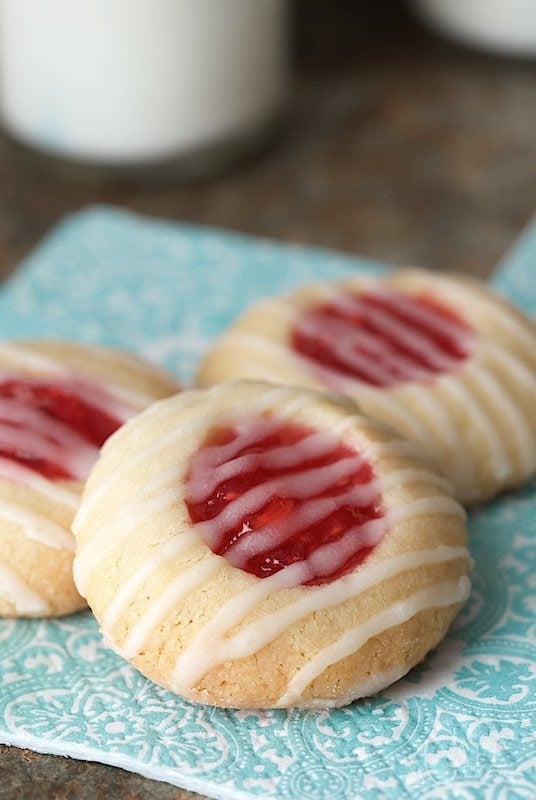 Vertical photo of Peach Raspberry Thumbprint Cookies on a turquoise napkin.