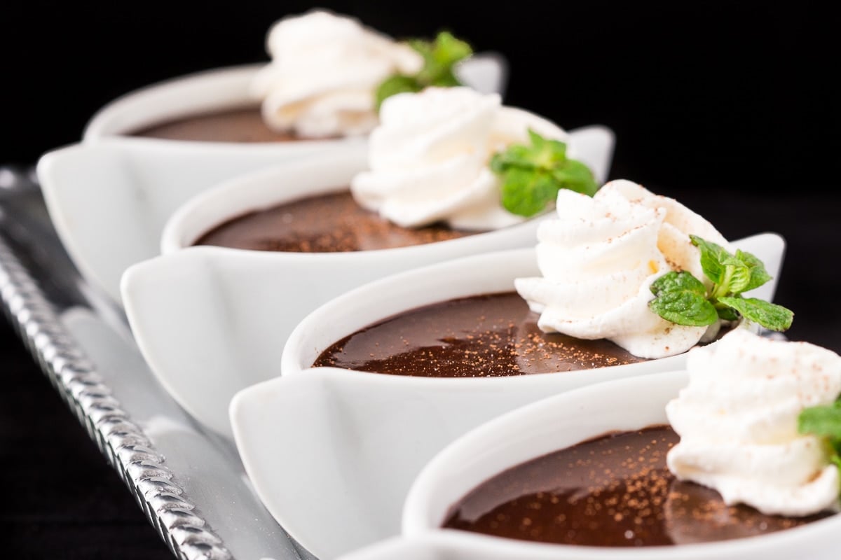 Horizontal closeup photo of a set of Ridiculously Easy Blender Chocolate Pots de Crème in oval ramekins.