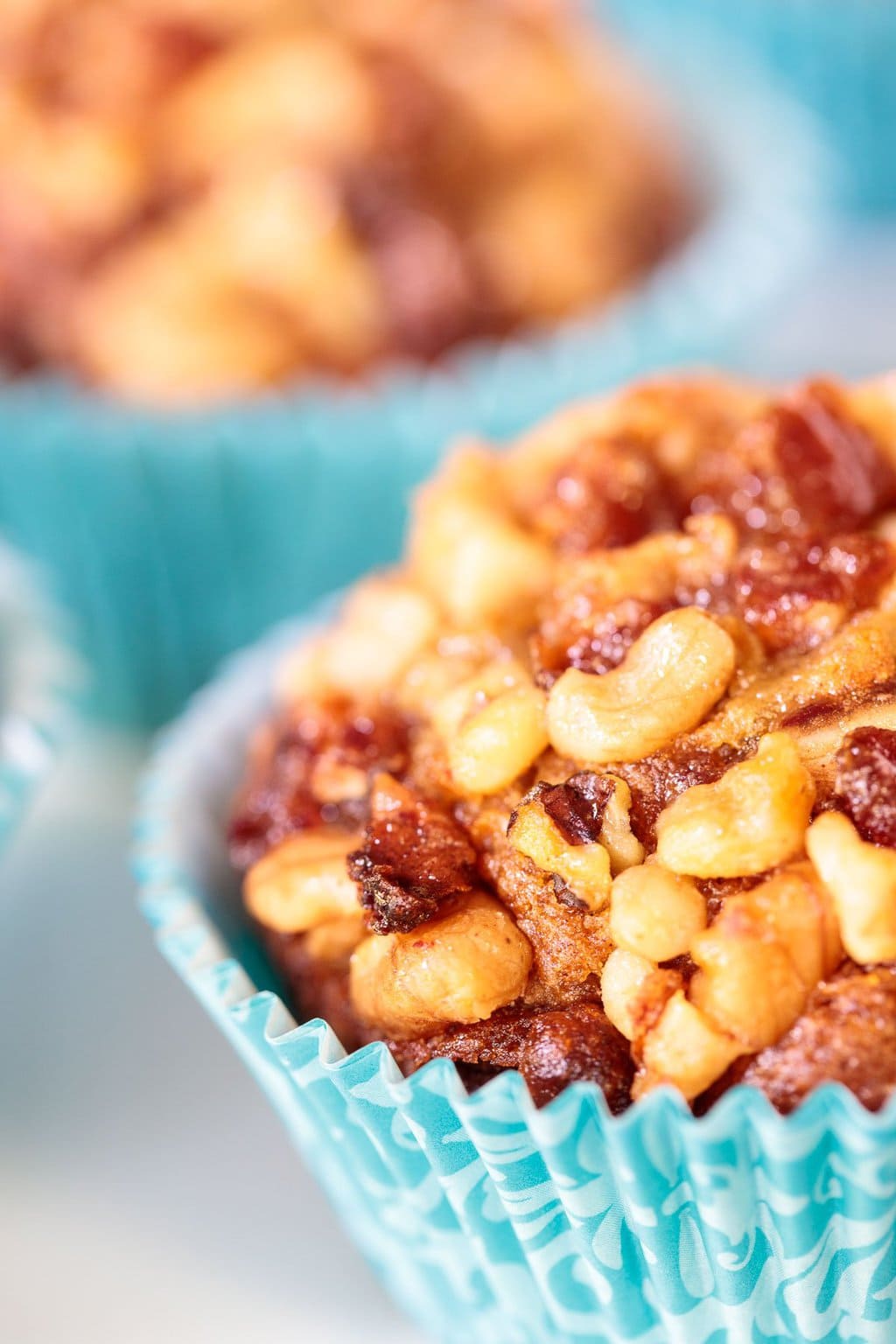 Vertical extreme closeup photo of Candied Walnut Date Banana Muffins in turquoise cupcake liners.