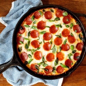 Horizontal overhead photo of a Easy Deep Dish Pepperoni and Basil pizza utilizing Easy Deep Dish Pizza Dough.