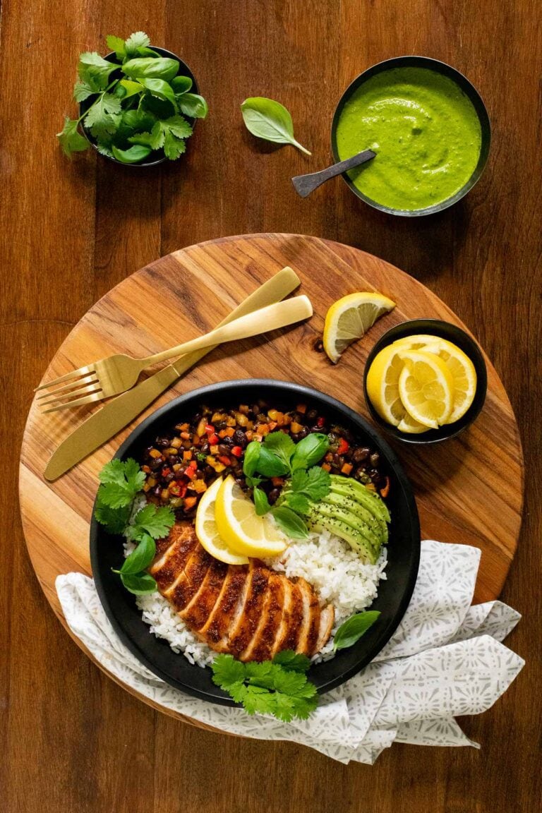 Overhead vertical photo of Peruvian Chicken and Rice Bowls on a round wooden platter.