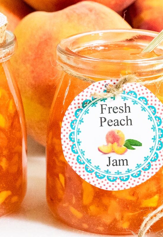 Horizontal closeup photo of a batch of Peach Freezer Jam with custom labels for gift giving.