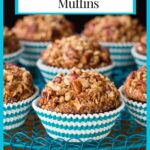 Vertical closeup photo of a batch of Morning Glory Muffins in white and turquoise striped muffin cups.