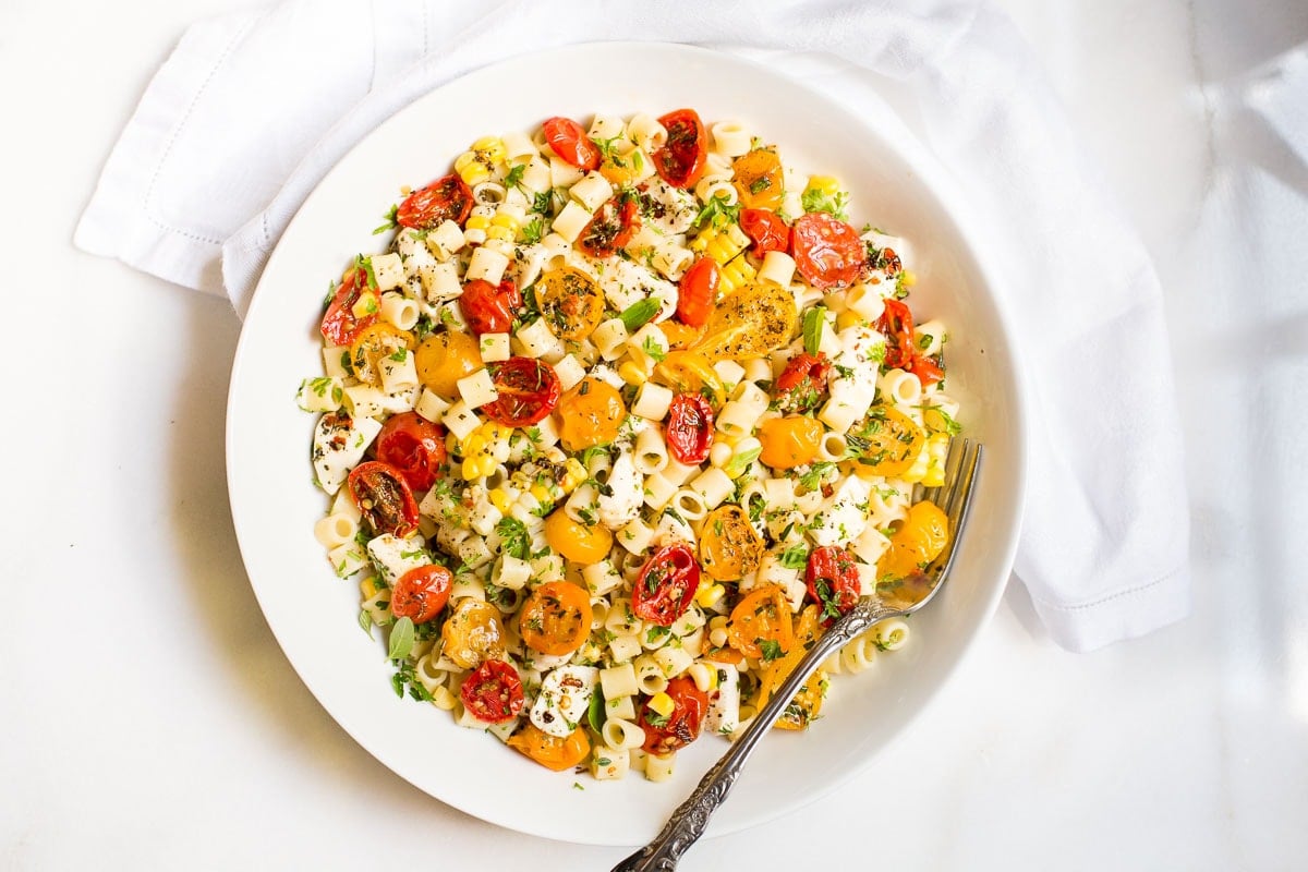 Horizontal overhead photo of Garlic Herb Roasted Tomatoes on a white serving plate.
