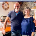 Vertical photo of Franca and Marcello in their Italian kitchen.