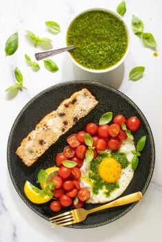 Vertical overhead picture of eggs and tomatoes and bread with Chimichurri sauce