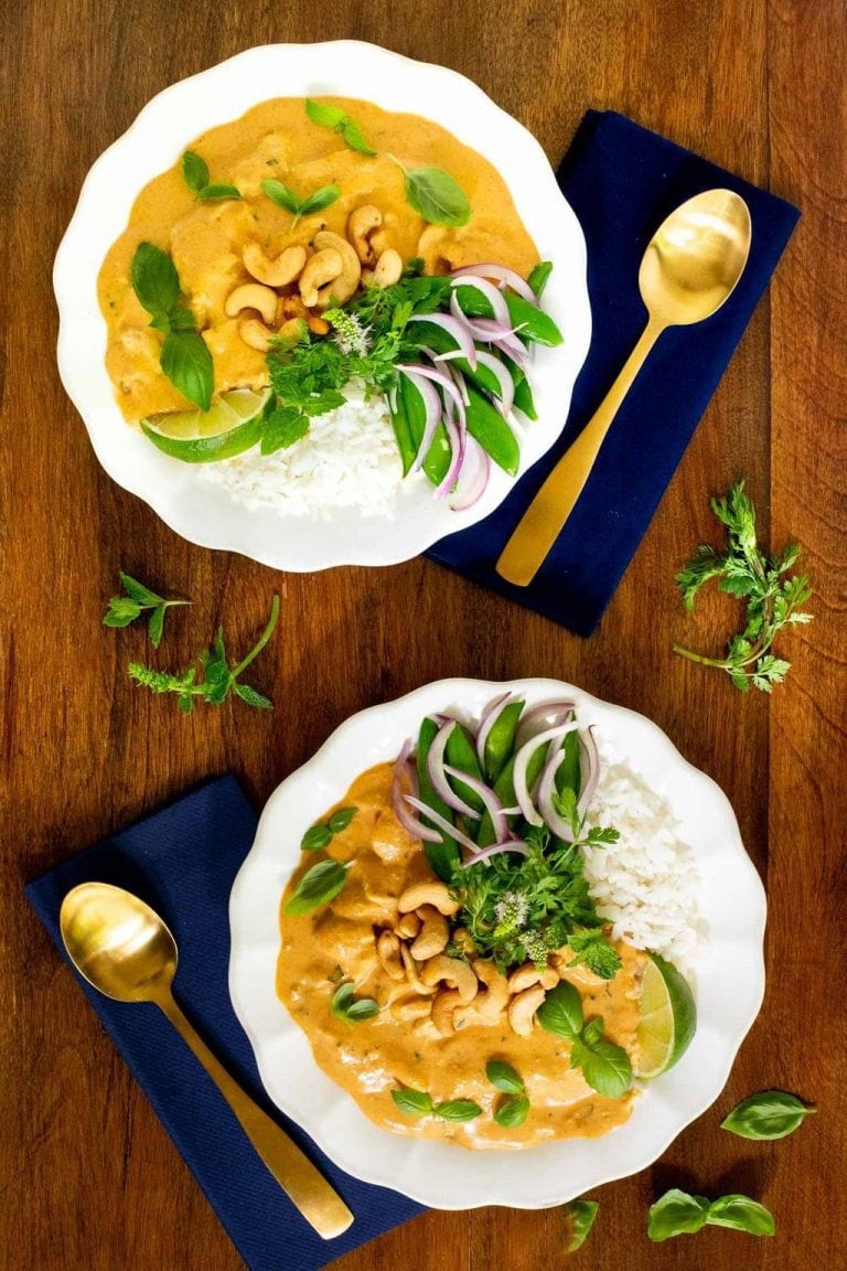 Vertical overhead picture of Basil Coconut Chicken on white plates with navy napkins