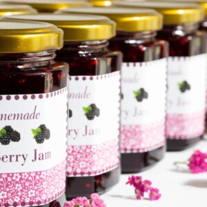 Horizontal closeup photo of a diagonal row of jars of Blackberry Freezer Jam.