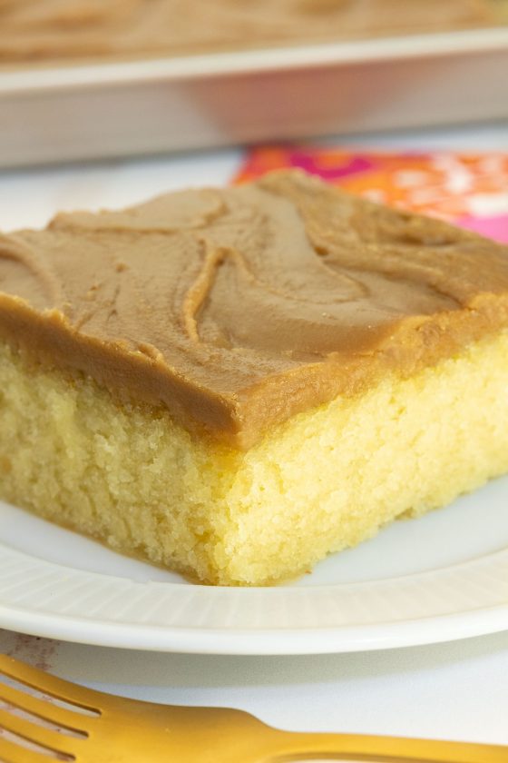 Vertical closeup photo of a Caramel Buttermilk Sheet Cake on a white serving plate.