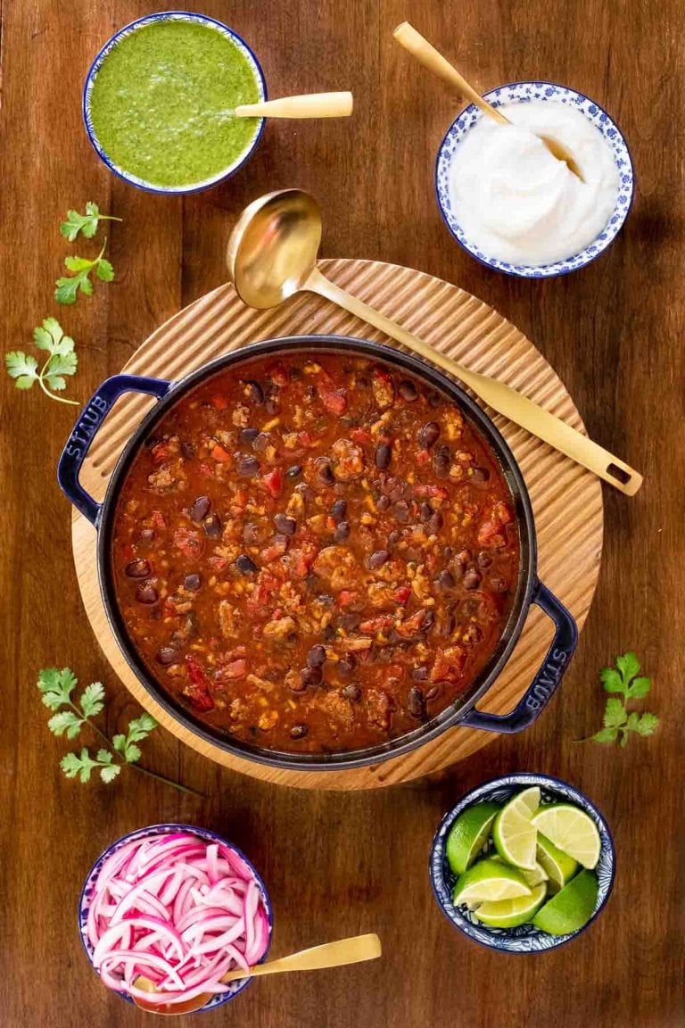 Vertical overhead photo of a pot of Black Bean Turkey Chili on a wood table.