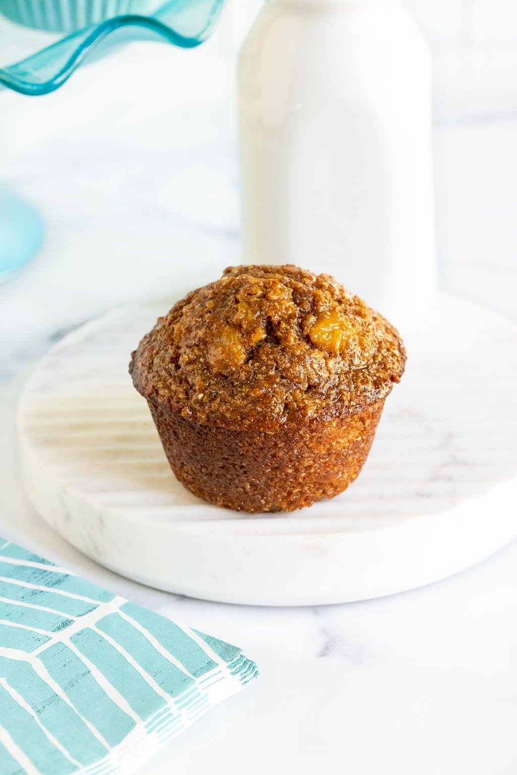 Vertical photo of a Honey-Glazed Pineapple Coconut Bran Muffins on a marble serving platter.