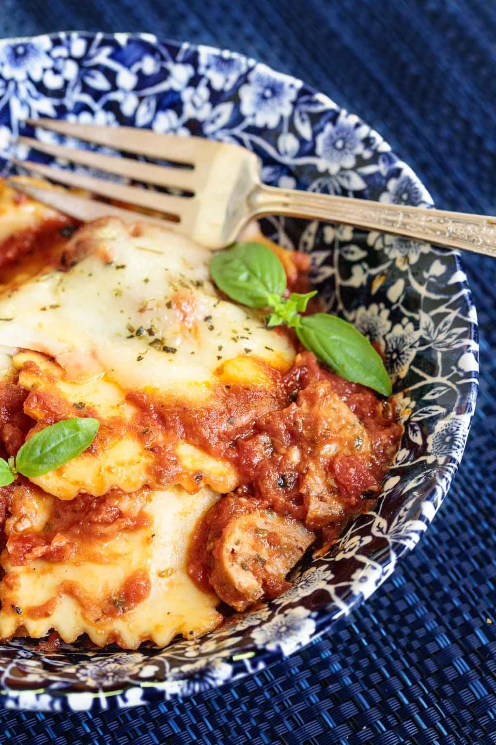 Vertical closeup photo of an individual serving bowl of Italian Chicken Sausage Ravioli Lasagna.