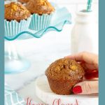 Vertical photo of a batch of Honey-Glazed Pineapple Coconut Bran Muffins with a person helping themselves to a muffin. A word graphic title is at the bottom of the photo.