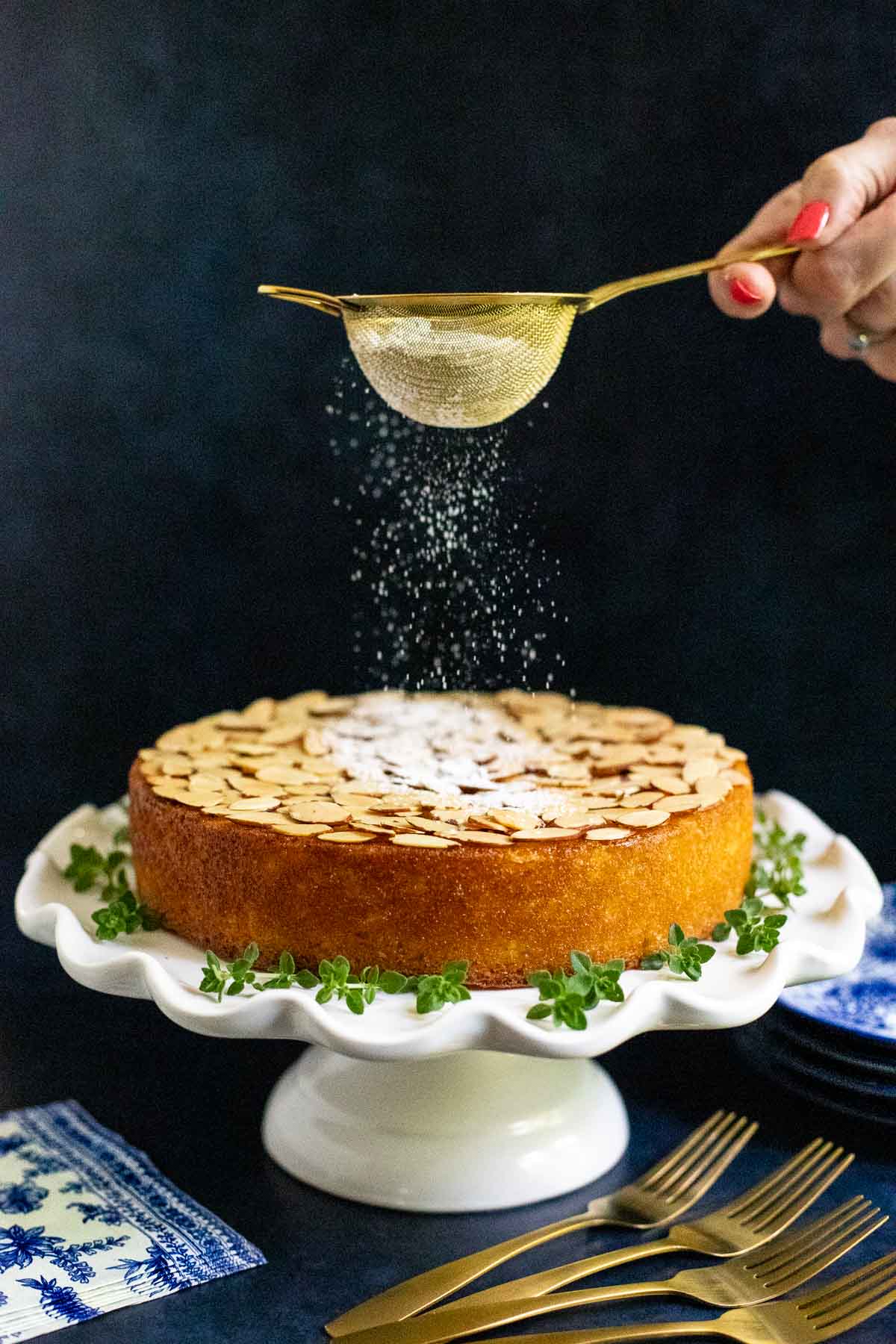 Vertical picture of Easy Almond Coconut Cake being dusted with powdered sugar