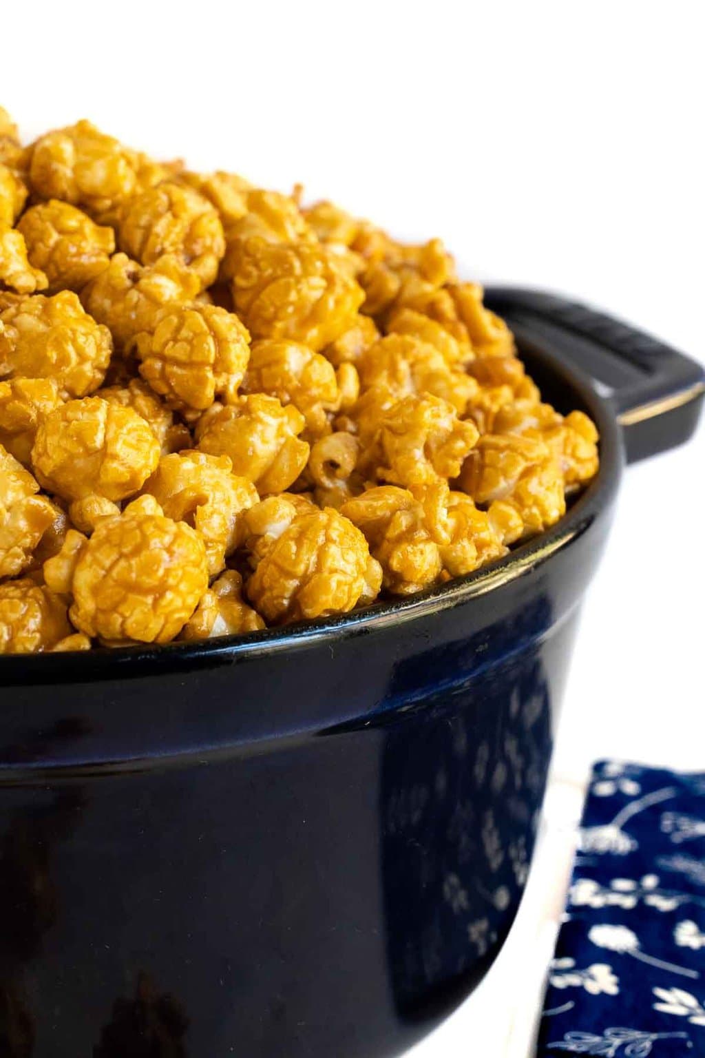 Extreme closeup vertical photo of a batch of Ridiculously Easy Sea Salted Microwave Caramel Corn in a dark blue Weck pot.