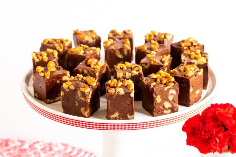 Horizontal photo of a batch of Chocolate Fantasy Fudge on a white pedestal serving plate.