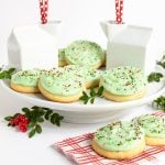 Horizontal photo of a batch of Copycat Crumbl Christmas Sugar Cookies on a white pedestal serving plate.