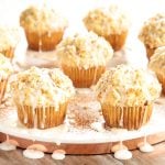 Horizontal photo of a batch of Eggnog Crumble Muffins on a white marble platter.