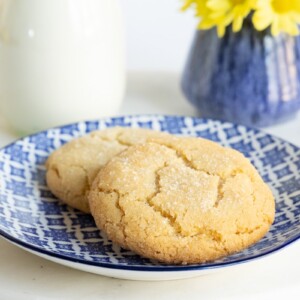Horizontal photo of a pair of Crinkly Crackly Lemon Sugar Cookies on a blue and white patterned serving plate.