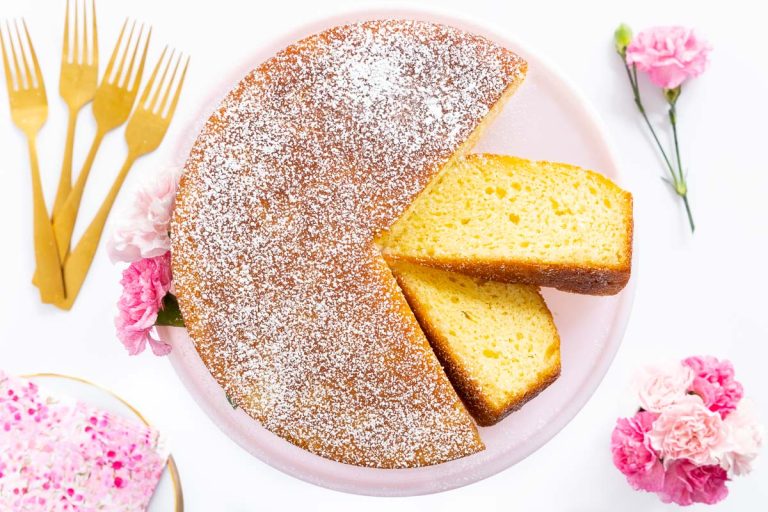 Horizontal overhead photo of a Ridiculously Easy French Butter Cake on a pink pedestal cake stand.