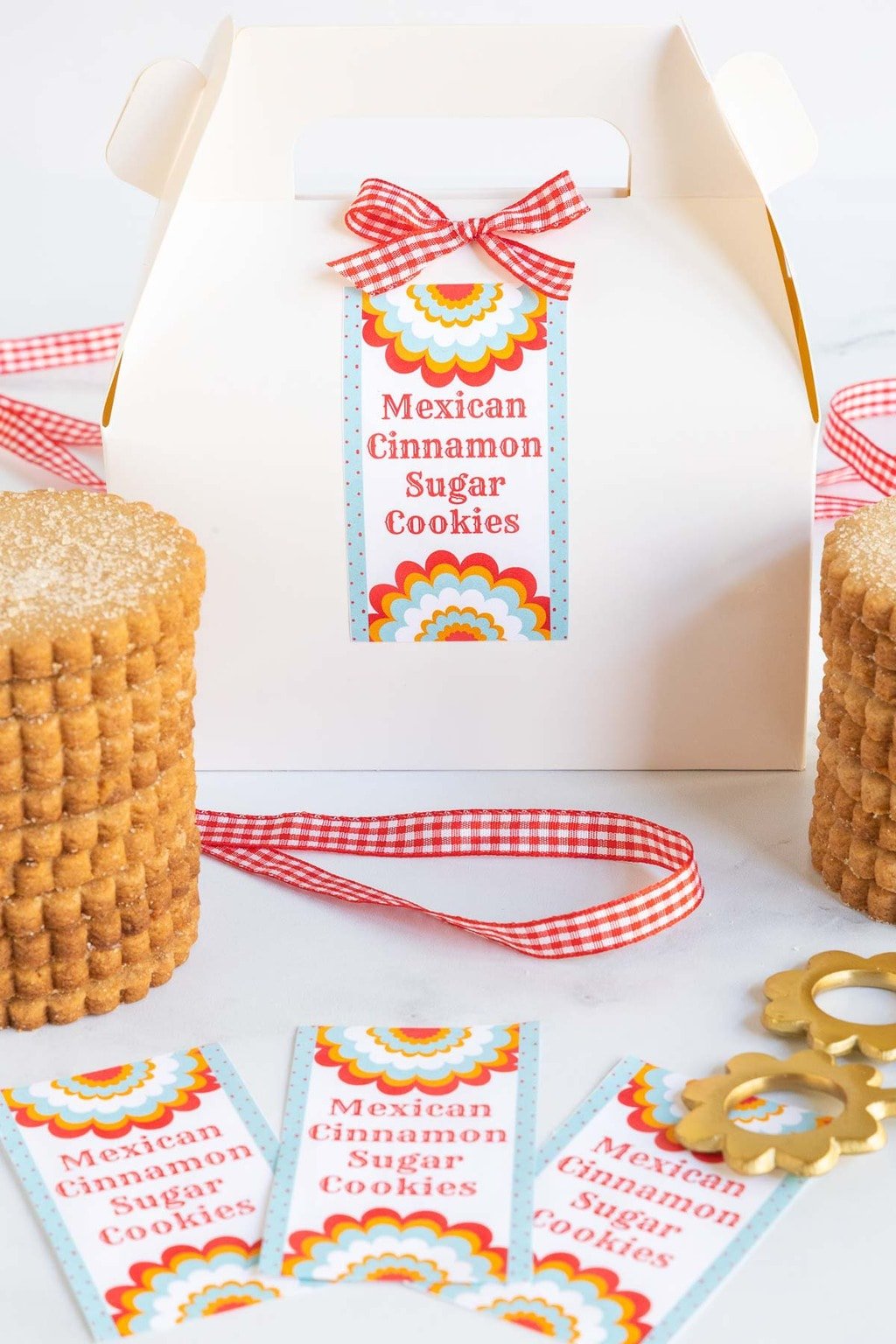 Vertical photo of a gift box for giving Mexican Cinnamon Sugar Shortbread Cookies to friends, co-workers, anyone! Custom gift labels are also in the photo.