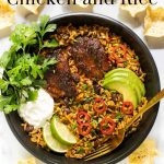Vertical overhead photo of a serving bowl of One-Pot Mexican Chicken and Rice surrounded by tortilla chips.