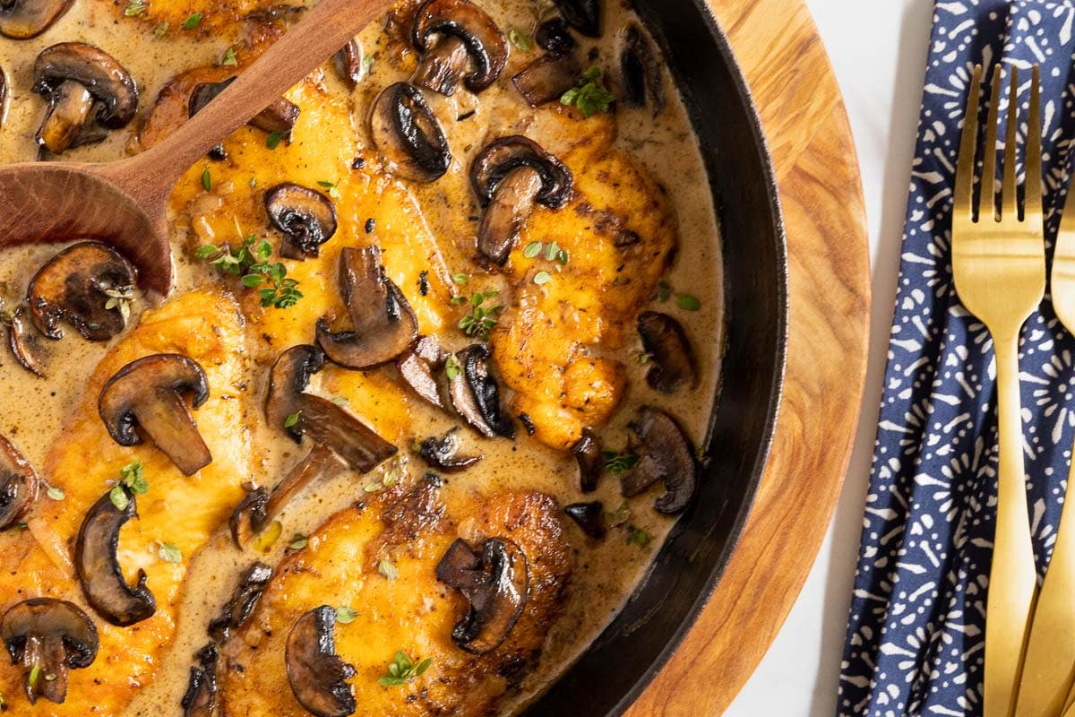 Overhead horizontal closeup photo of Weeknight or Dinner Party Chicken Marsala in a black cast iron pan.