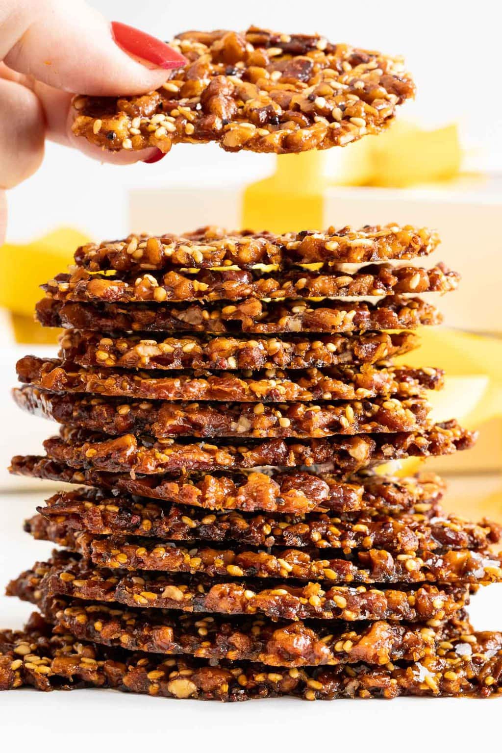 Vertical extreme closeup photo of a stack of Sea Salted Quinoa Pecan Brittle.