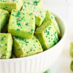Vertical closeup photo of a batch of Leprechaun Shortbread Bites in a white serving bowl.