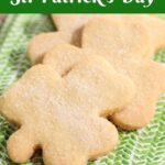 Vertical extreme closeup photo of a batch of Irish Shortbread Cookies in the shape of shamrocks.