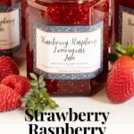 Vertical closeup photo of jars of Strawberry Raspberry Lemongrass Jam with custom labels for gift giving. A word graphic title is at the bottom of the photo