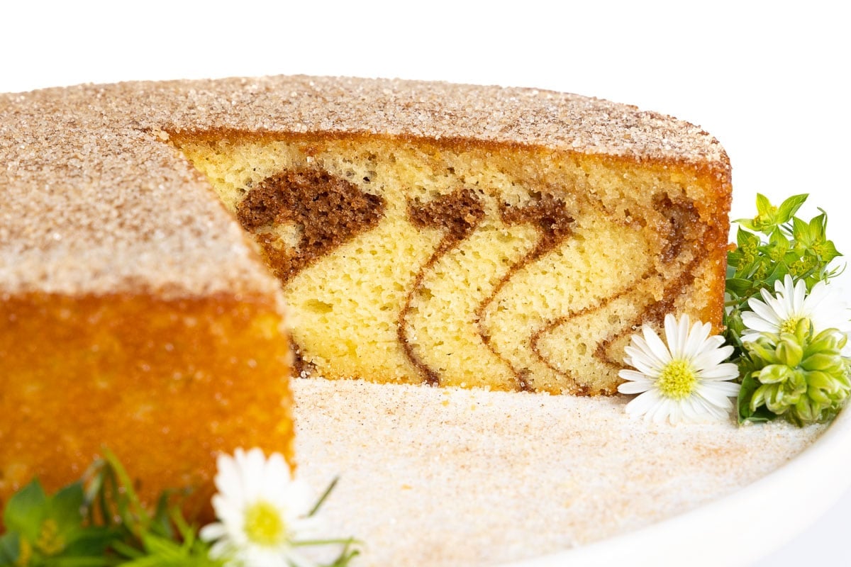 Horizontal closeup photo of the inside of a Mexican Churro Cake surrounded by decorative flowers.