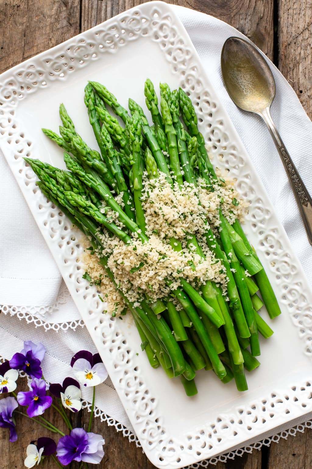 Vertical overhead photo of a white lattice serving plate with Asparagus with Lemon Parsley Panko.