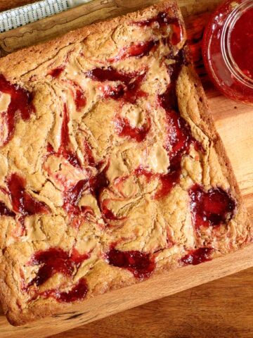 Horizontal overhead photo of Peanut Butter and Jelly Blondies on a wood table.