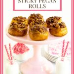 Vertical photo of a batch of Ridiculously Easy Sticky Pecan Rolls on a pale pink platter with jars of milk in the foreground.