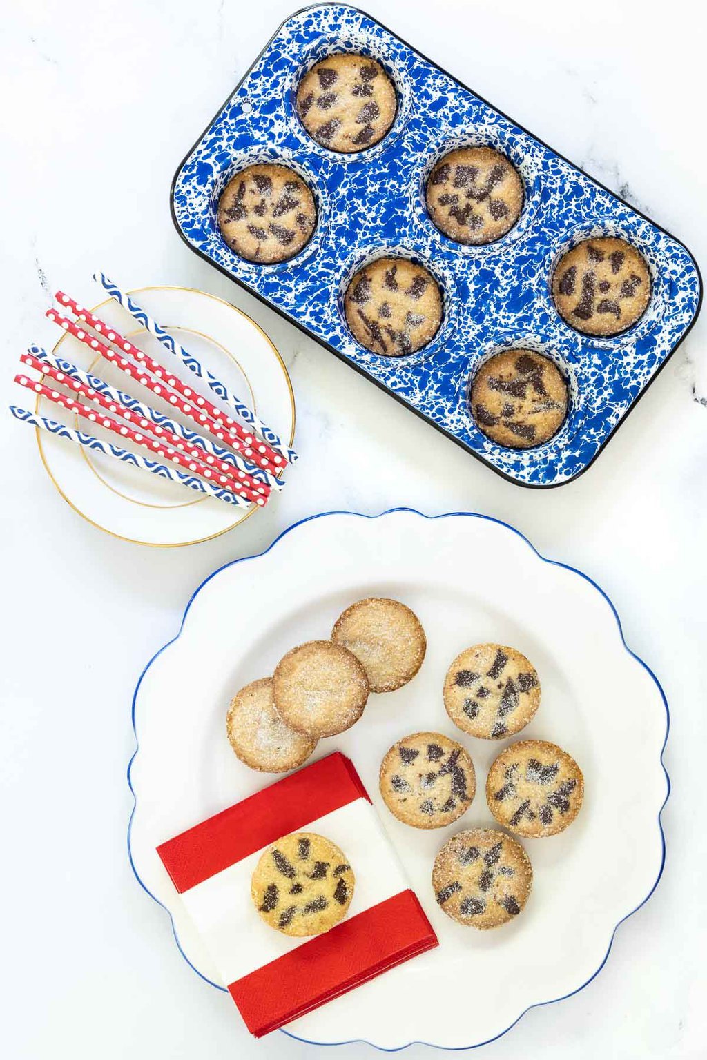 Vertical overhead photo of a batch of Ridiculously Easy Peanut Butter Shortbread Cookies on a white plate and in a blue and white speckled muffin pan.
