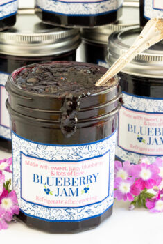 Horizontal closeup photo of jars of Easy 30 Minute Blueberry Jam with custom labels for gift giving.