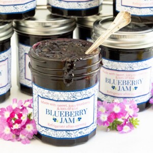 Horizontal closeup photo of jars of Easy 30 Minute Blueberry Jam with custom labels for gift giving.