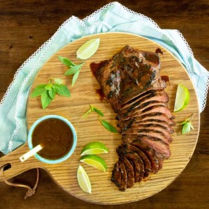 Horizontal overhead photo of Steve's Grilled Asian Steak on a round wood cutting board.