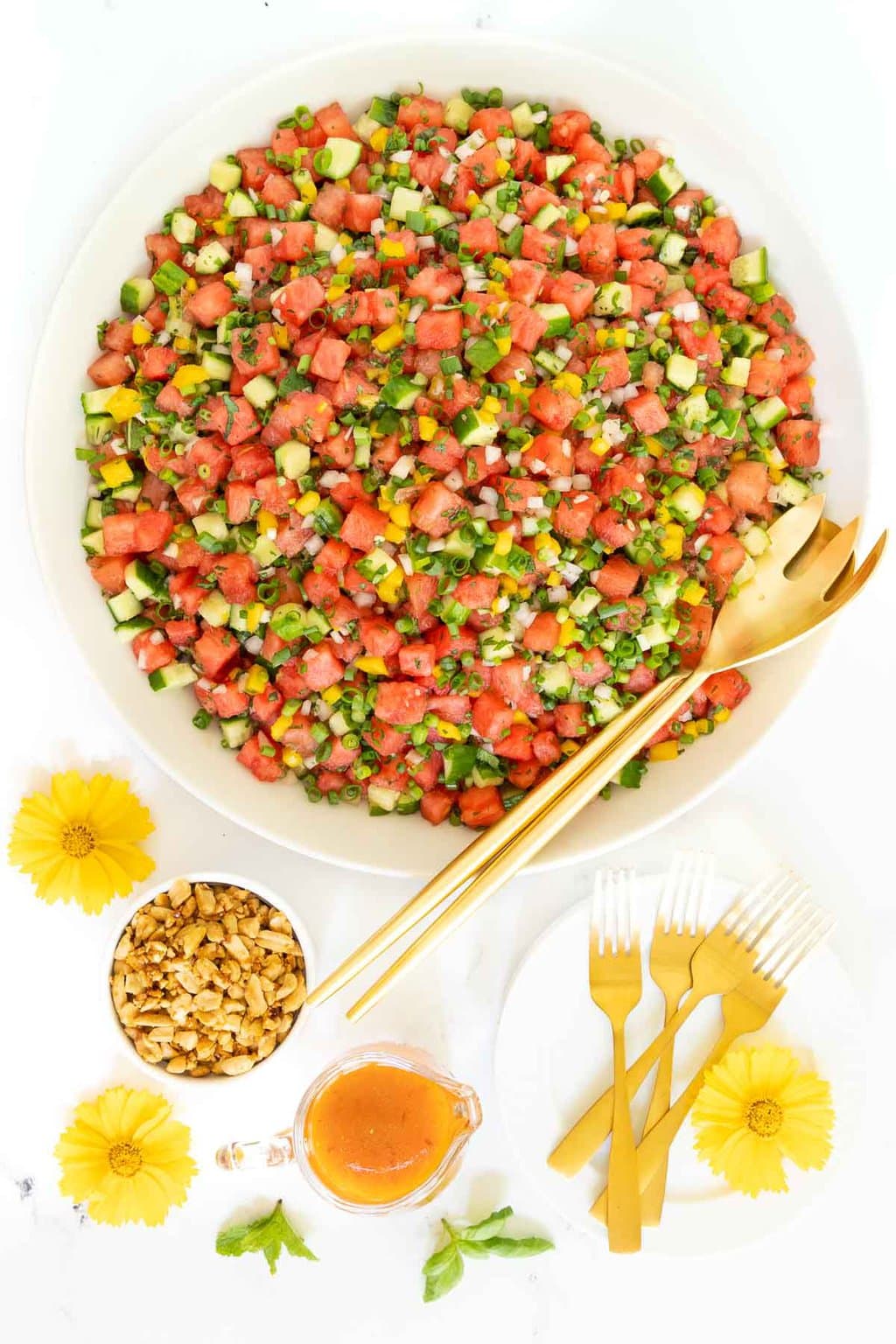 Vertical overhead photo of Thai Chopped Watermelon Salad in a white serving bowl with yellow flowers.