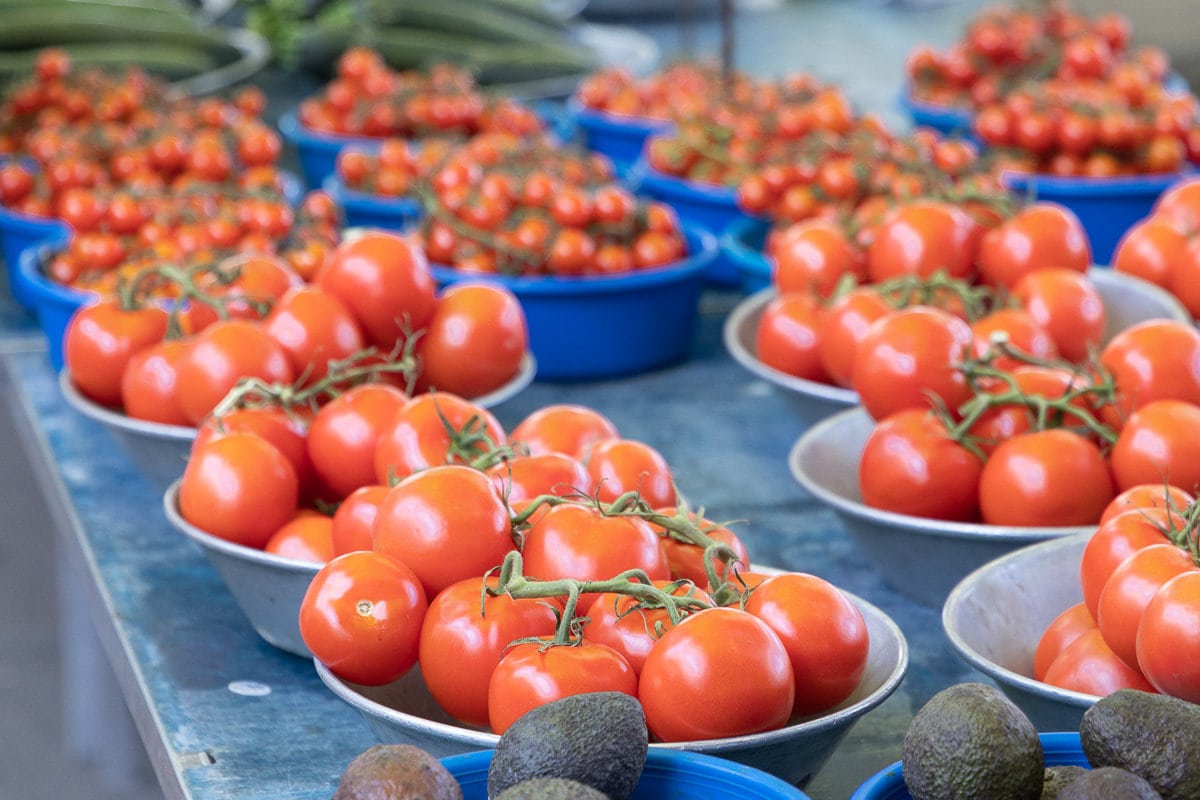 Horizontal closeup photo of crates of fresh mini tomatoes at a Lyon France street market.