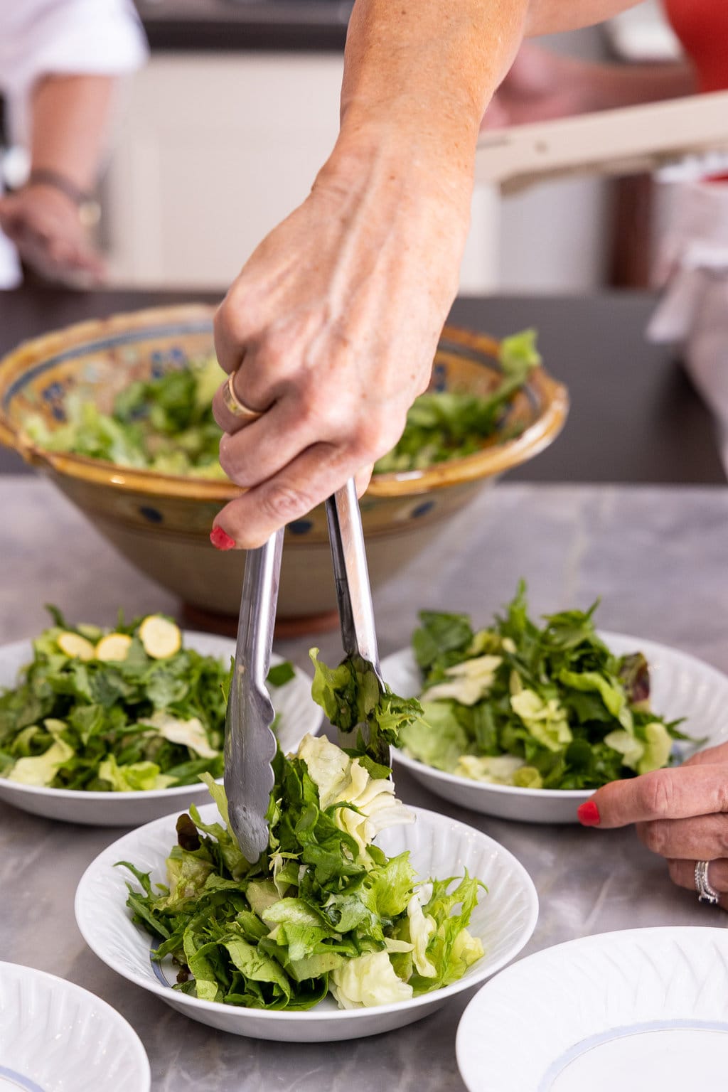 Vertical photo of a person preparing a salad at Plum Cooking school in Lyon, France.