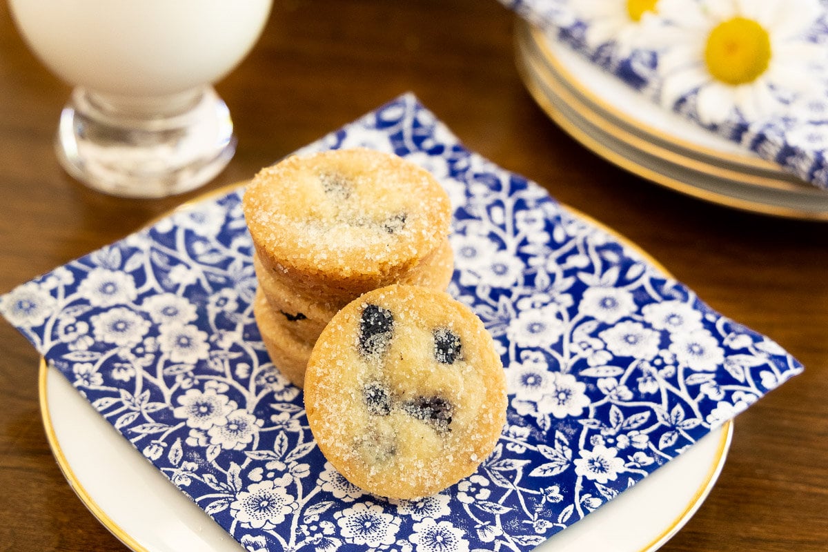 Horizontal photo of a stack of Ridiculously Easy Lemon Blueberry Shortbread Bites on a blue and white patterned napkin.