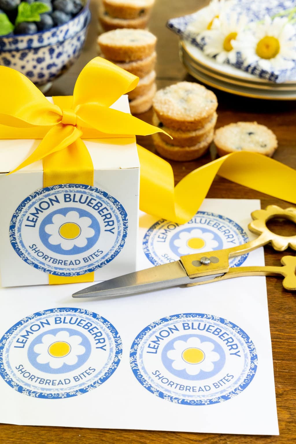 Vertical photo of custom Ridiculously Easy Lemon Blueberry Shortbread Bite labels and a box for custom gift giving.